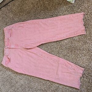 Pink jeans lightly distressed at bottom in pocket